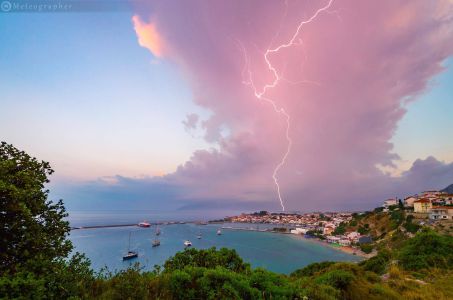 Isolated Storm Cell Spewing a Beautiful Lightning Bolt (Pythagoreio, Greece). On 27th May, when a very strong - for this season - low hit Aegean with extreme instability and major storms that caused floods and power blackouts. This shot shows an isolated storm cell spewing a beautiful lightning bolt with a colourful sunrise behind me. The seaside village under the storm is Pythagoreio, the birthplace of ancient mathematician, Pythagoras.